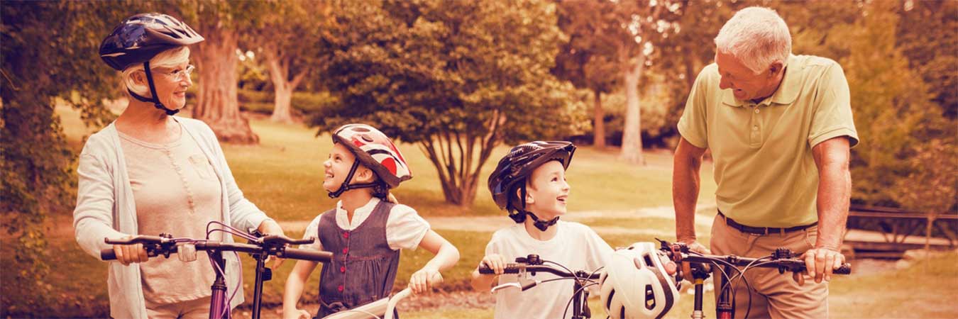 Grands-parents qui font du vélo avec leurs petits enfants à la Toussaint dans nos gîtes ruraux